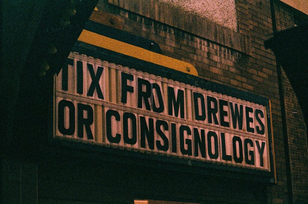 A vintage cinema marquee sign displaying text at night, offering a nostalgic urban vibe.