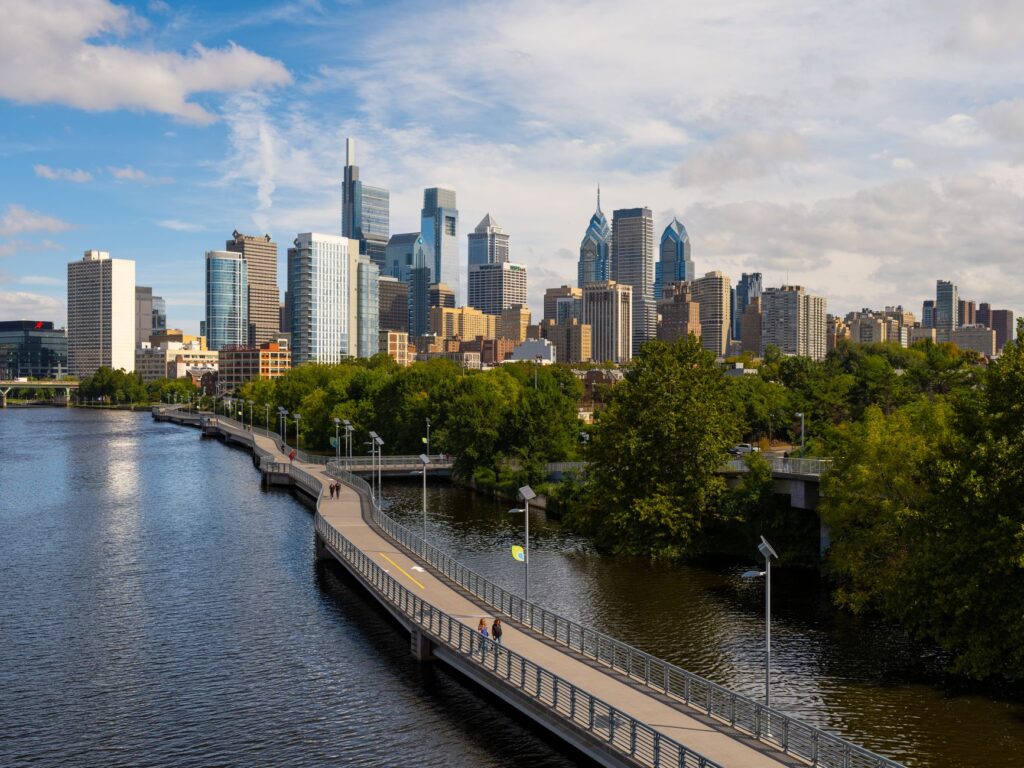 Stunning view of Philadelphia skyline with Schuylkill River and boardwalk in the foreground.